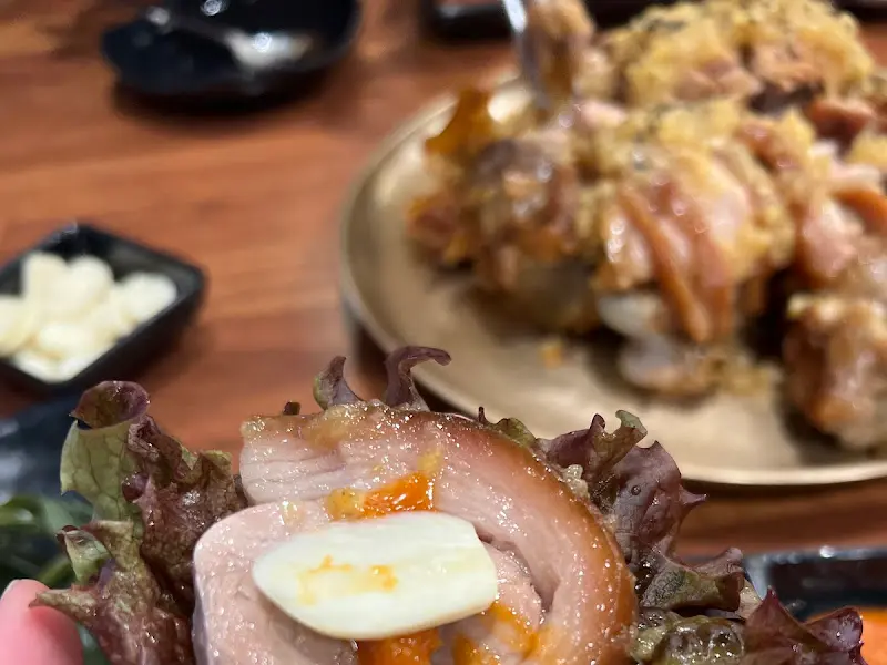 족발 한 점을 쌈에 싸서 먹는 모습