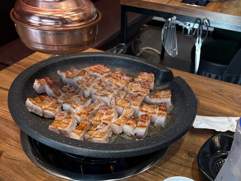 불판 위에 가지런히 놓인 삼겹살