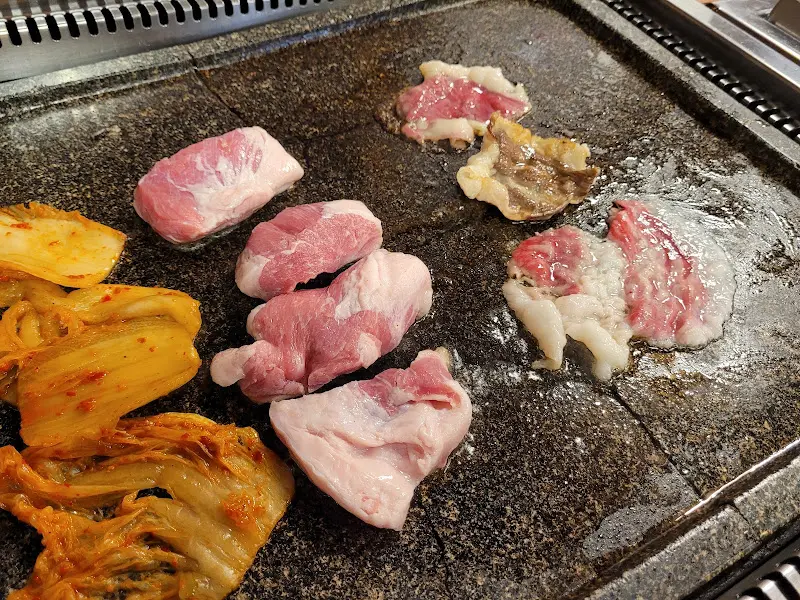 불판 위에서 익어가는 오겹살과 김치