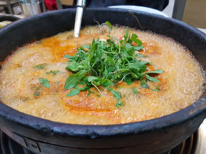 냉이가 듬뿍 올려진 부대찌개의 모습