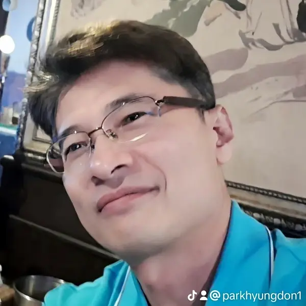 안경을 쓰고 미소를 짓고 있는 남성의 클로즈업