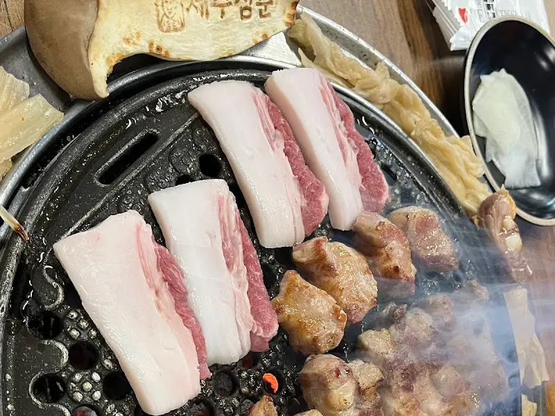 불판 위에서 익어가는 흑돼지와 버섯