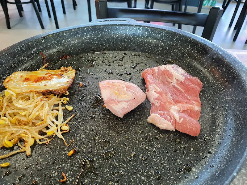 돌판 위의 삼겹살과 김치, 콩나물