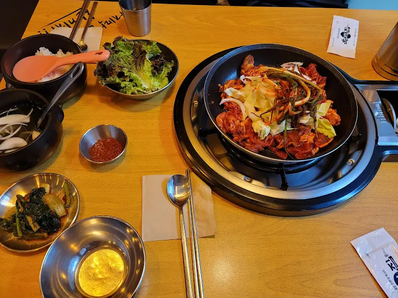 솥뚜껑에 담긴 고추장 돼지 불고기와 쭈꾸미 구이