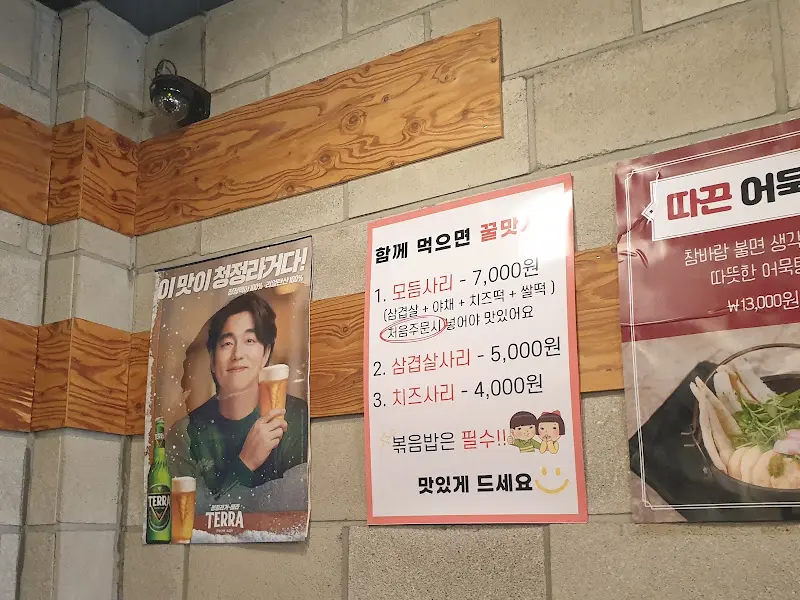 벽에 붙은 메뉴 안내 및 테라 광고 포스터