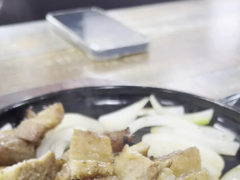 뜨거운 철판 위에 양파와 함께 놓인 양푼갈비