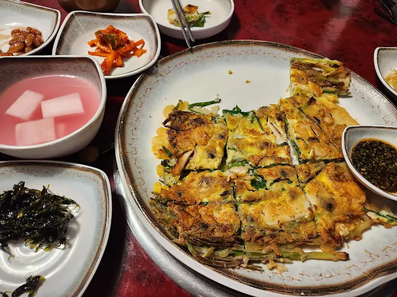 노릇하게 구워진 해물파전과 다양한 곁들임 반찬