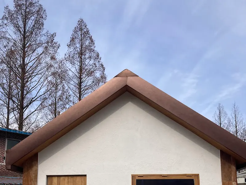 카페 건물 외관: 깔끔한 흰색 벽과 갈색 지붕이 조화롭다.