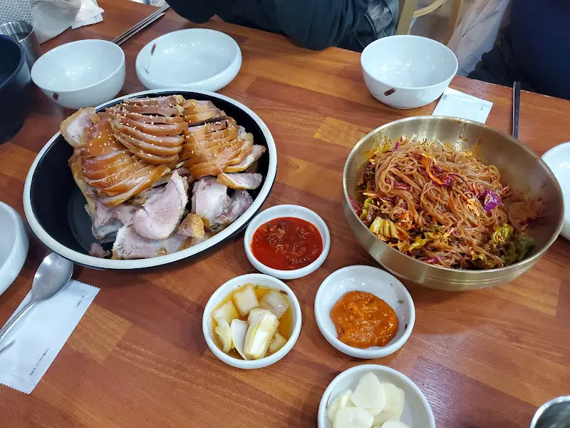 족발과 보쌈이 함께 담겨져 있고, 막국수와 곁들임 반찬들이 테이블 위에 놓여진 모습