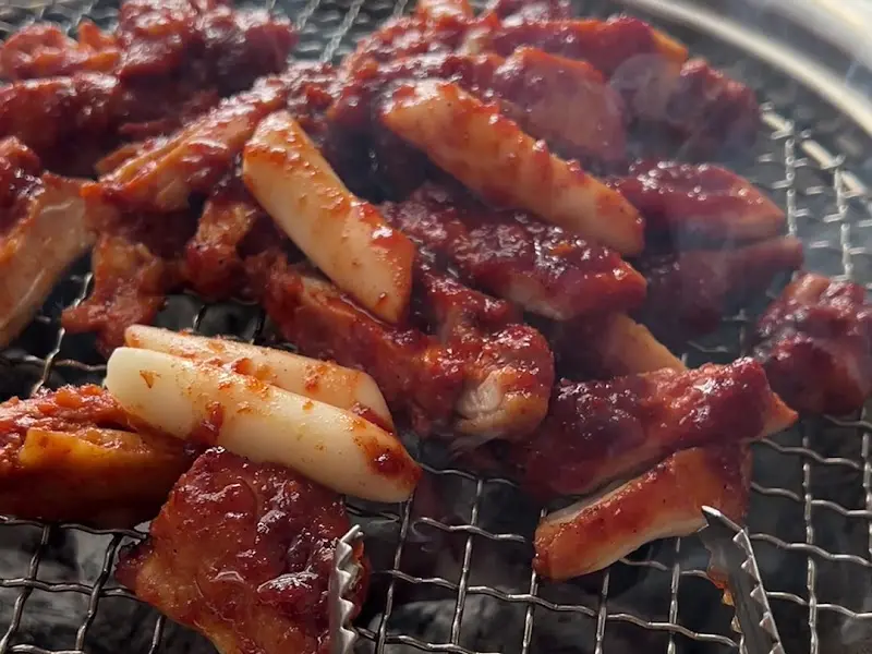 숯불 위에서 익어가는 닭갈비와 떡