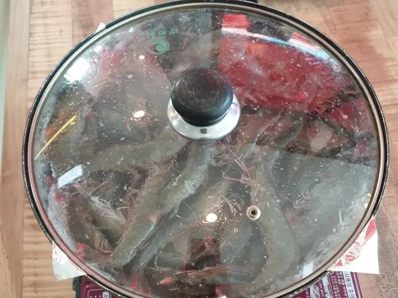 테이블 위에서 끓고 있는 새우 냄비