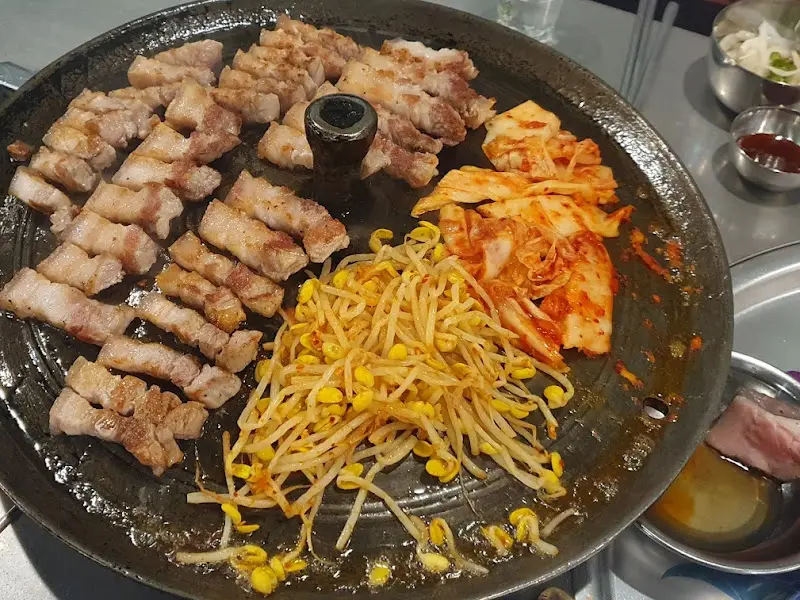 노릇하게 구워진 삼겹살과 김치, 콩나물