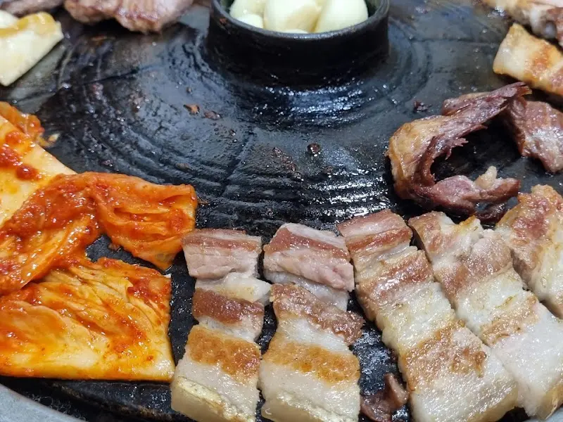 삼겹살과 김치, 마늘이 함께 구워지는 모습