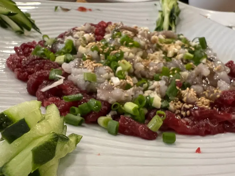 육회와 낙지, 신선한 채소가 어우러진 육회낙지 탕탕이의 클로즈업 샷