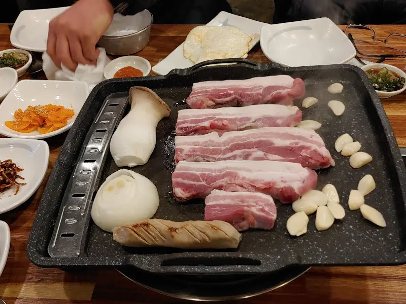 노릇하게 구워진 흑돼지 삼겹살과 마늘, 양파