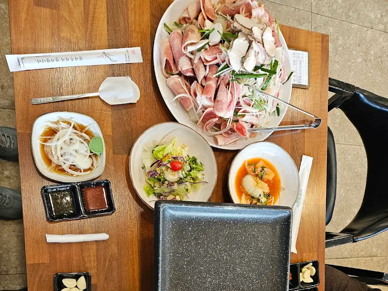 테이블 위에 푸짐하게 차려진 오리불고기 한 상 차림