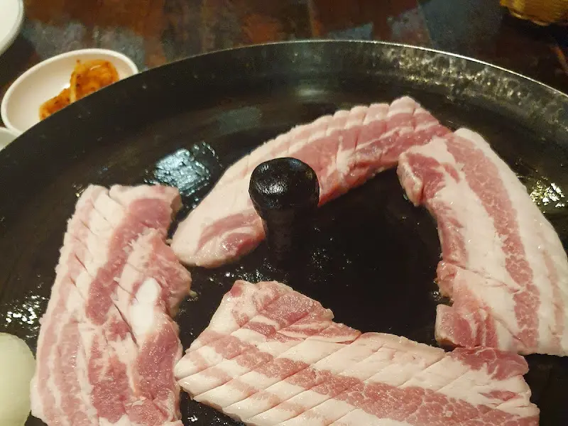 솥뚜껑에 구워진 삼겹살 근접 촬영