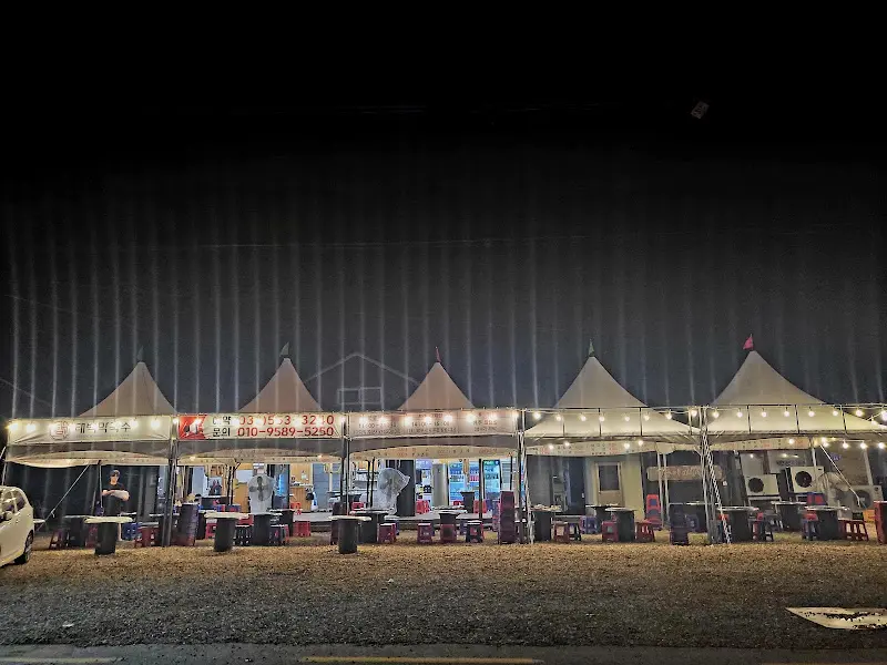 저녁 시간, 야외 테이블에 은은하게 불이 밝혀진 식당의 모습