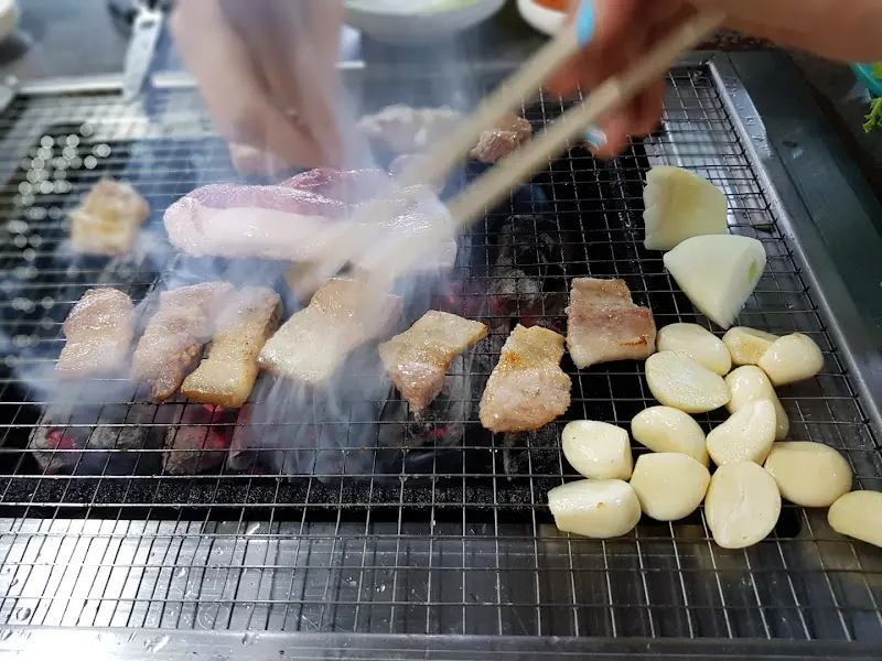 숯불 위에서 익어가는 흑돼지 삼겹살, 마늘, 양파