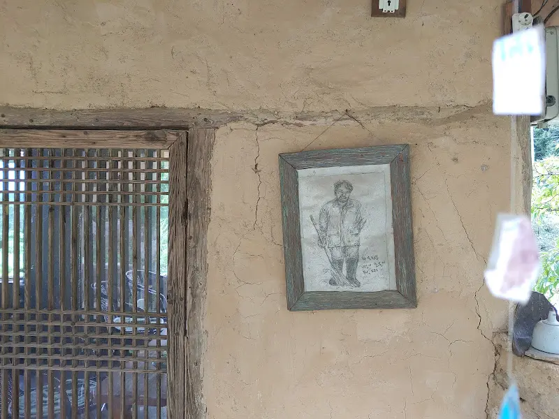 벽에 걸린 액자의 모습, 투박한 흙벽이 인상적이다.