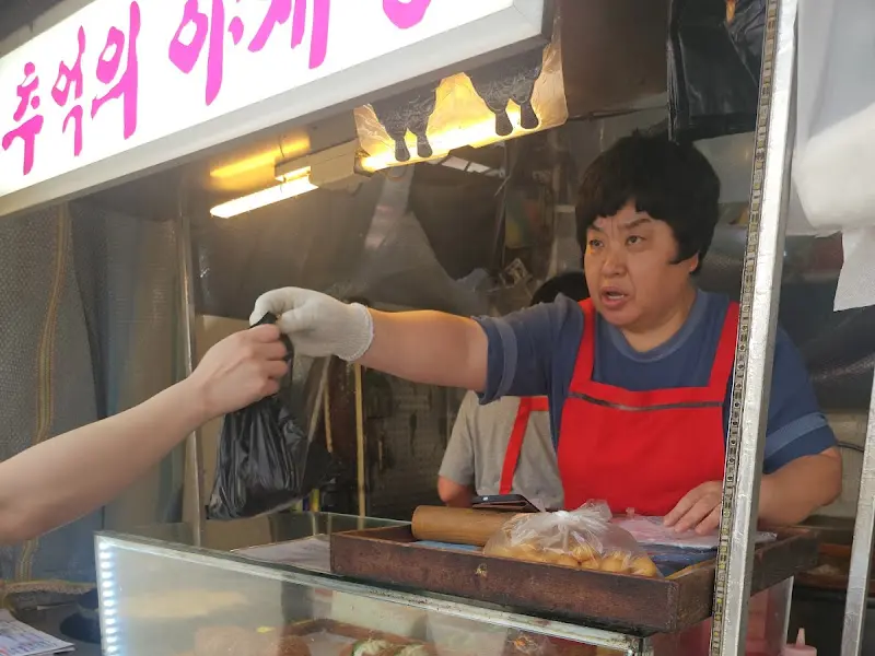 손님에게 야채빵을 건네는 주인 아주머니의 모습