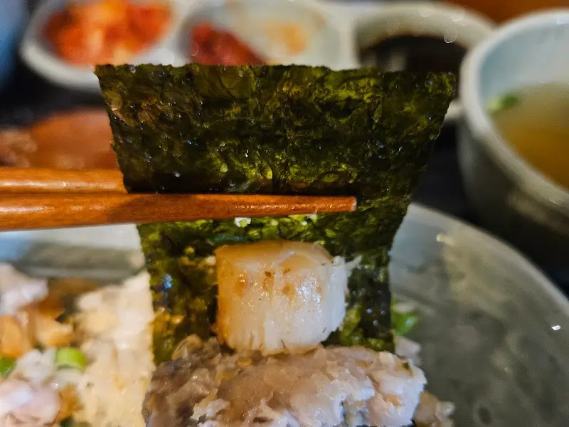 김에 밥과 관자를 올려 먹는 모습