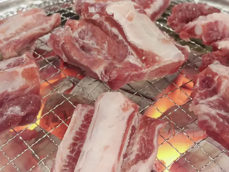 숯불 위에서 익어가는 생갈비의 클로즈업