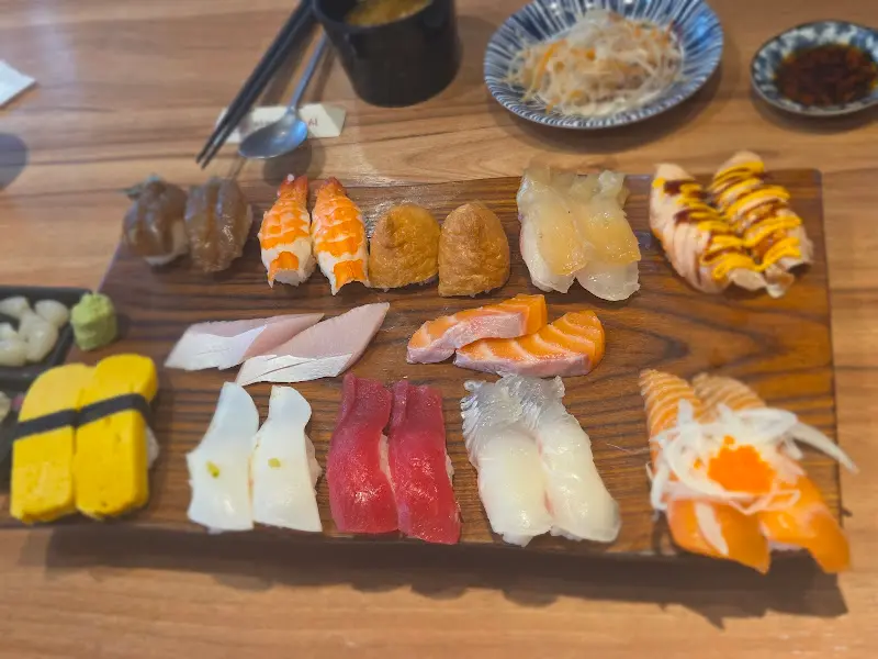 나무 도마 위에 красочно하게 담긴 초밥과 사시미