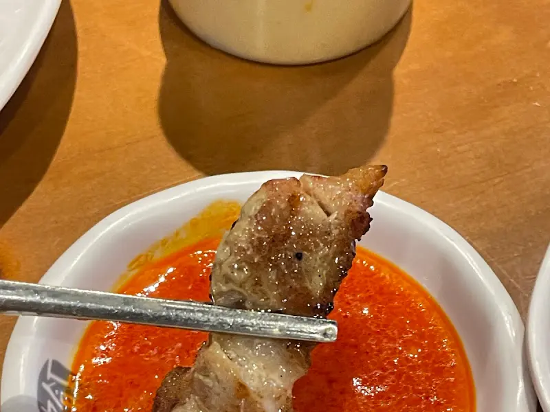 잘 구워진 목살을 소스에 찍어 먹는 모습