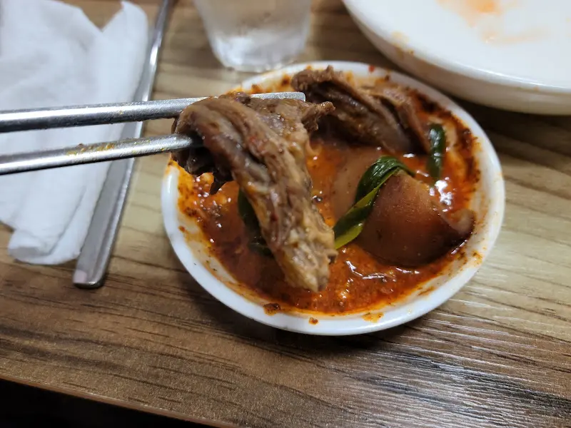 젓가락으로 집어 올린 뼈해장국 속 살코기