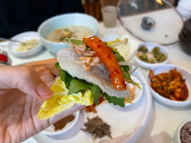 배추쌈에 수육, 쌈장, 미나리를 올려 한 입 가득