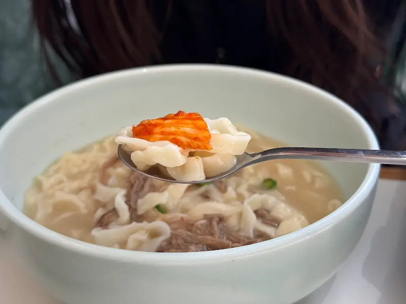 칼국수 면발 위에 김치를 올려 먹는 모습