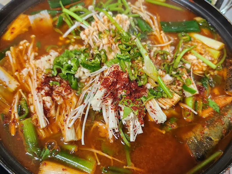 테이블 가득 채워진 매운탕, 밑반찬, 밥상이 풍족함을 느끼게 해준다.