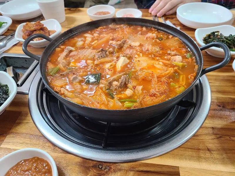 테이블 위에서 끓고 있는 김치찌개의 모습