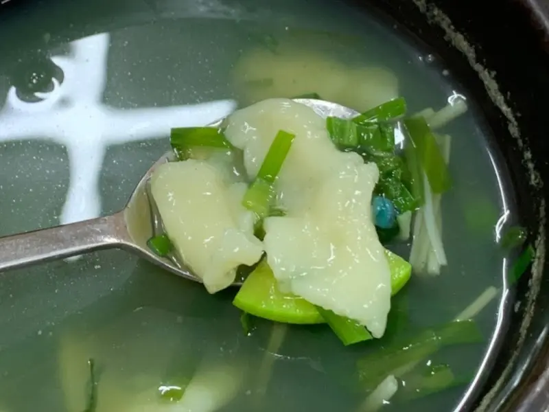 숟가락에 올려진 다슬기와 수제비