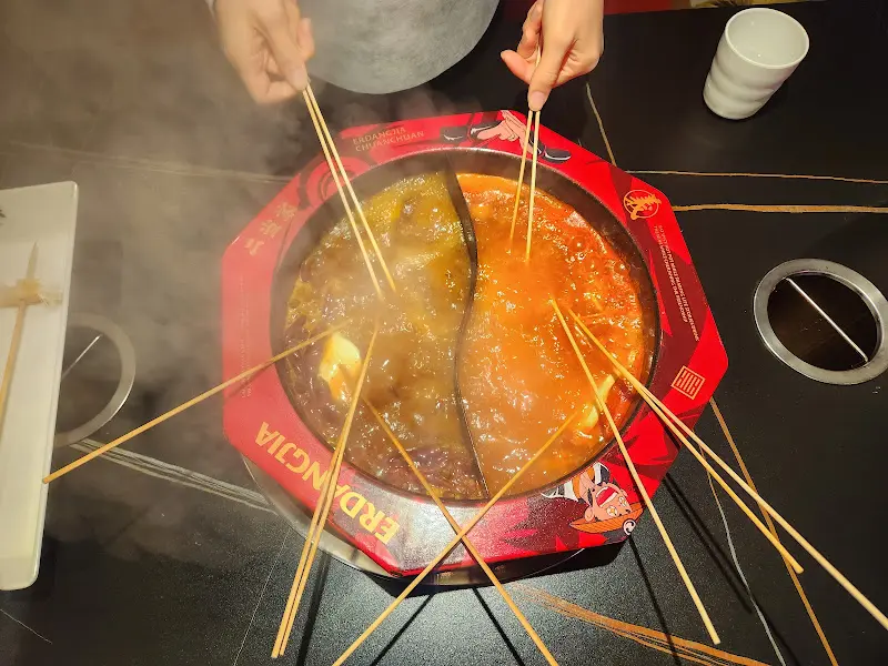 홍탕과 버섯탕에 꼬치를 넣어 익히는 모습