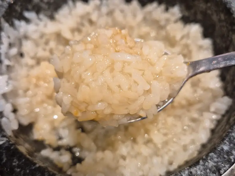 돌솥에 뜨거운 물을 부어 만든 누룽지를 숟가락으로 뜬 모습