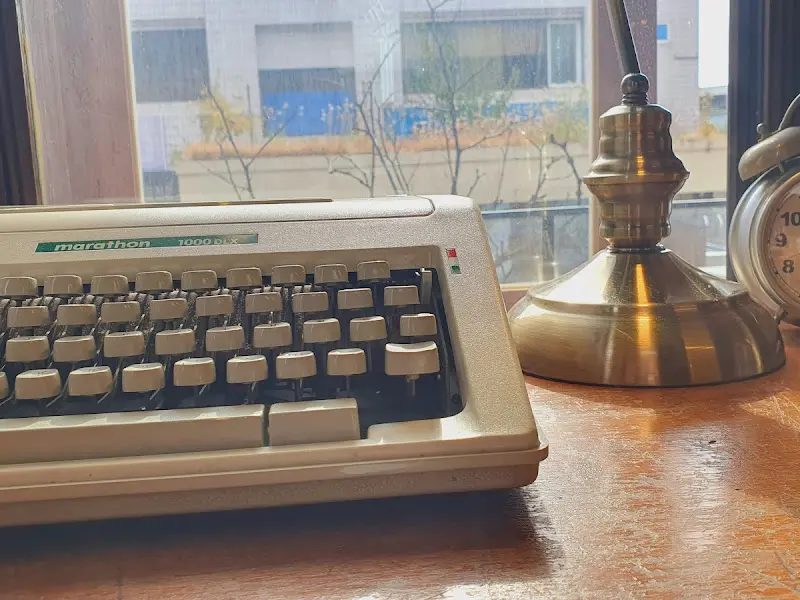 빈티지 타자기와 앤티크 스탠드가 놓인 테이블