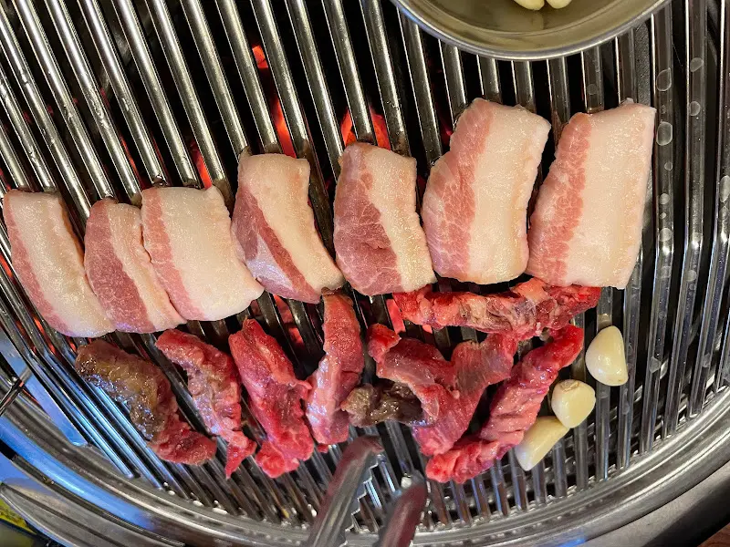 숯불 위에서 노릇하게 구워진 삼겹살