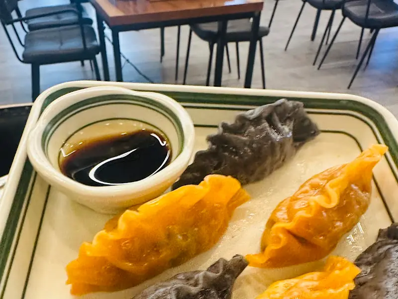 검은색, 주황색 만두와 간장