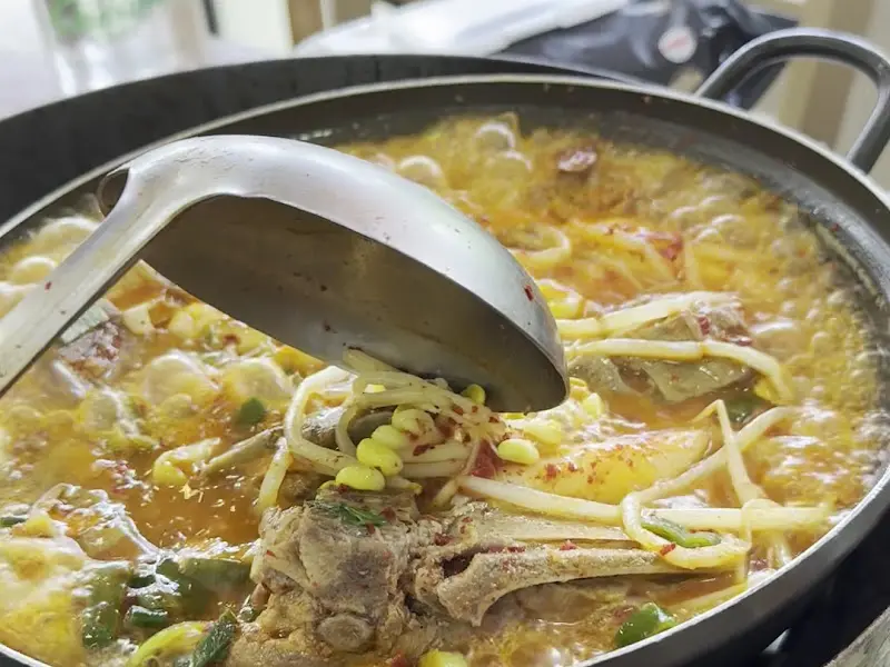 국자로 감자국을 뜨는 모습