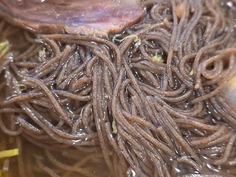 검은 빛깔의 칡냉면 같은 면발