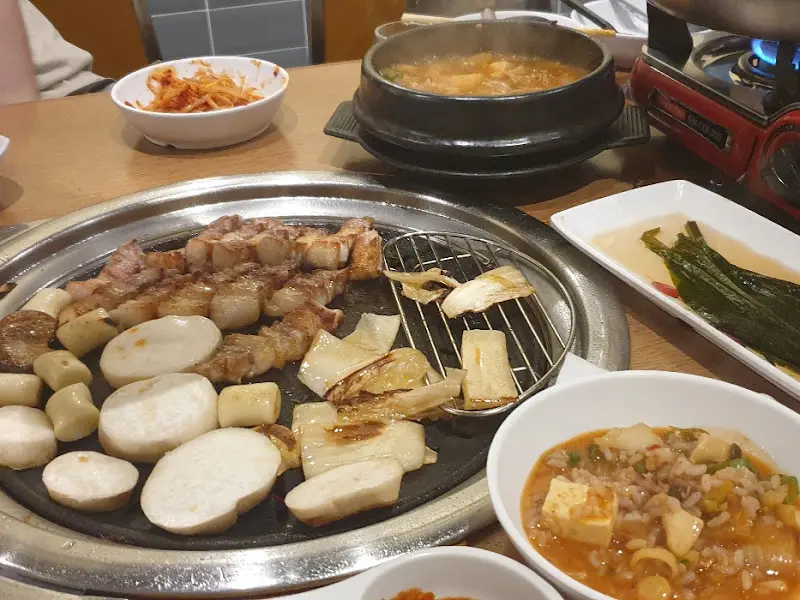 불판 위의 삼겹살과 김치찌개