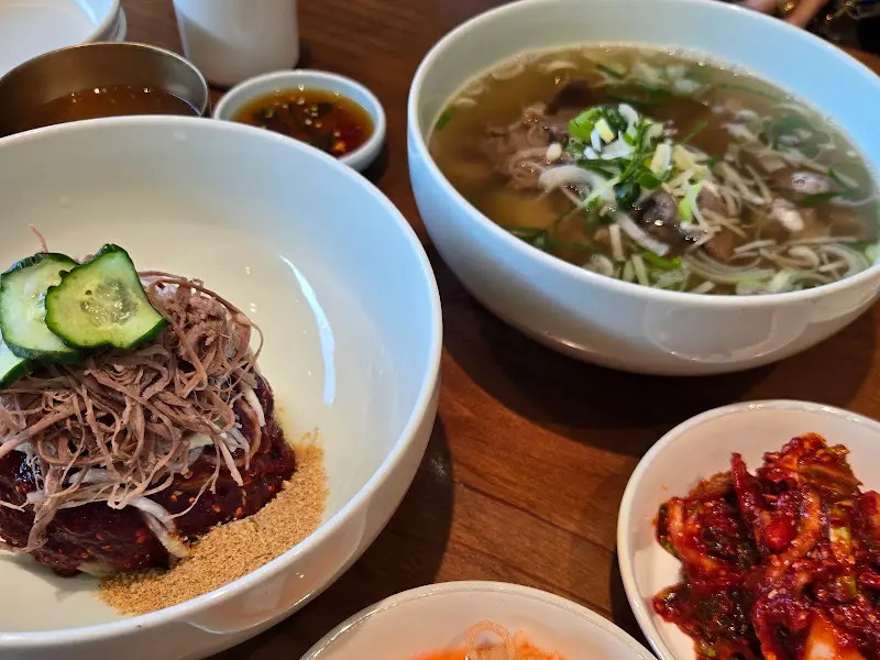 테이블 위에 놓인 평양냉면, 고사리 들기름 비빔냉면, 한우곰탕의 모습