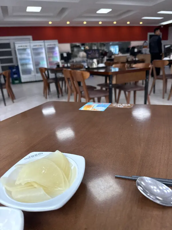 깔끔하게 정돈된 테이블과 식기류가 놓여진 짬뽕관 수원영통점의 내부 모습