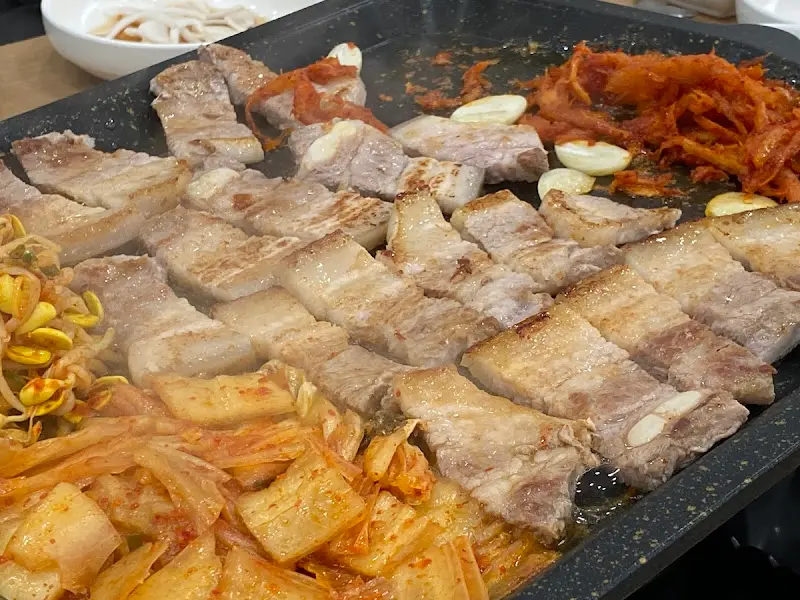 구워진 삼겹살과 김치, 마늘