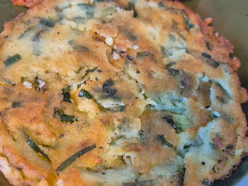 겉은 바삭하고 속은 촉촉한 녹두전의 클로즈업 사진. 부추가 썰어 들어가 있어 더욱 먹음직스럽다.