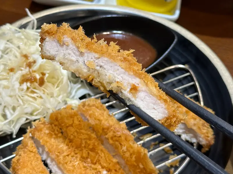 젓가락으로 돈까스를 집어 올린 모습