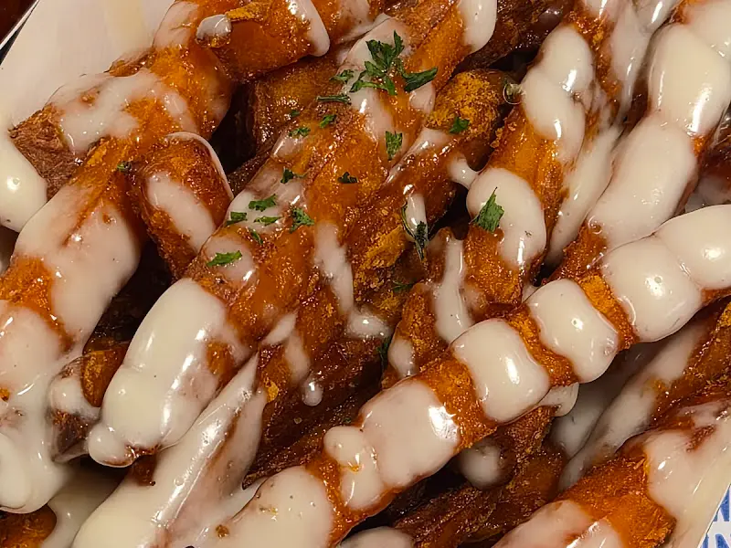 고구마 프라이에 하얀 소스가 뿌려진 모습