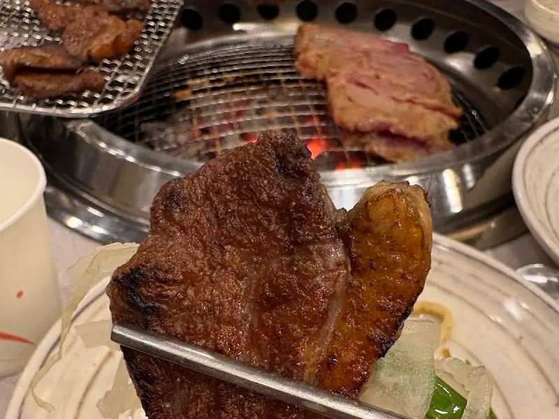 젓가락으로 집어 올린 윤기 흐르는 돼지갈비